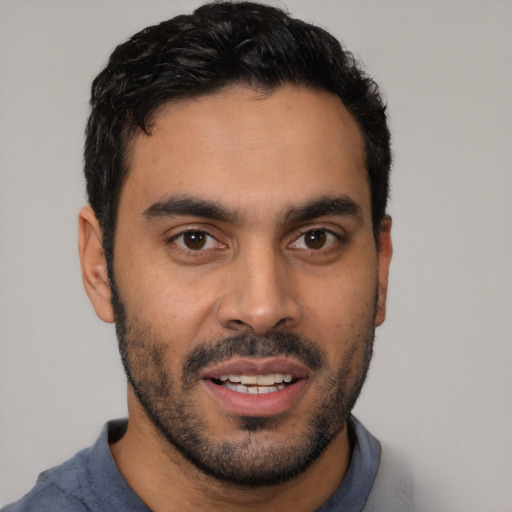 Joyful latino young-adult male with short  black hair and brown eyes