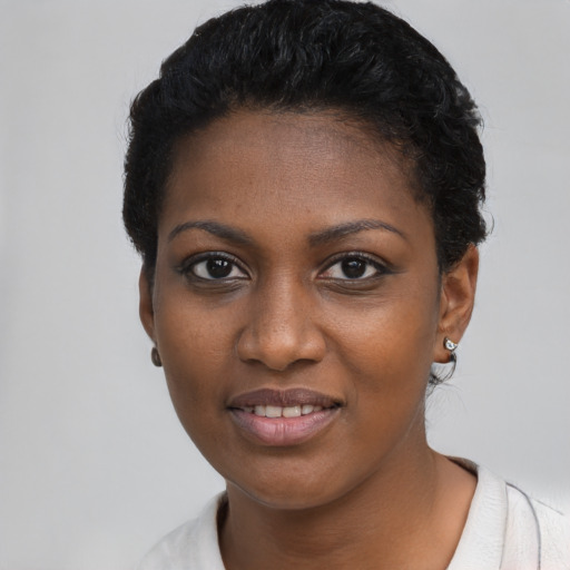 Joyful black young-adult female with short  black hair and brown eyes