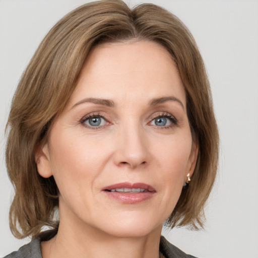 Joyful white adult female with medium  brown hair and grey eyes