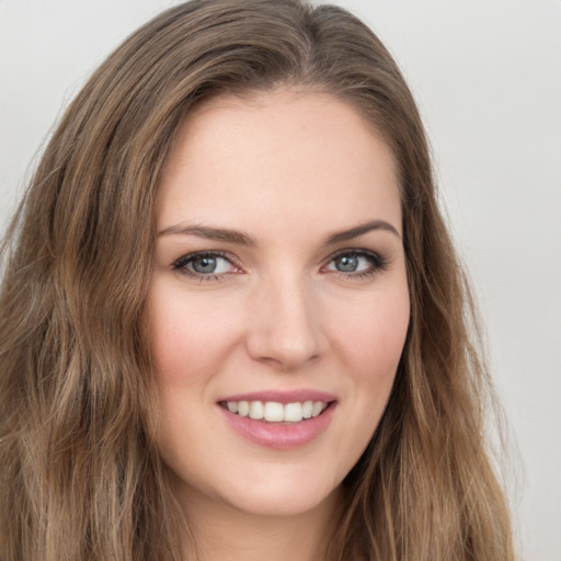 Joyful white young-adult female with long  brown hair and green eyes