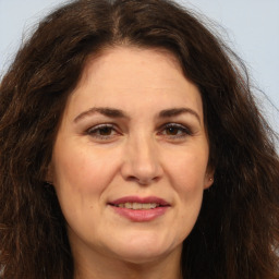 Joyful white adult female with long  brown hair and brown eyes