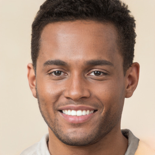 Joyful black young-adult male with short  brown hair and brown eyes