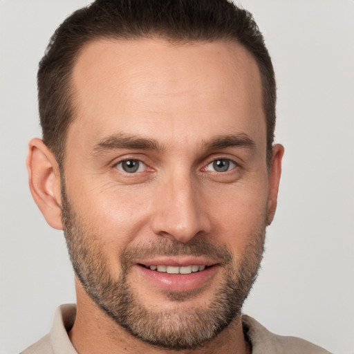 Joyful white young-adult male with short  brown hair and brown eyes