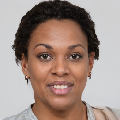 Joyful black young-adult female with short  brown hair and brown eyes