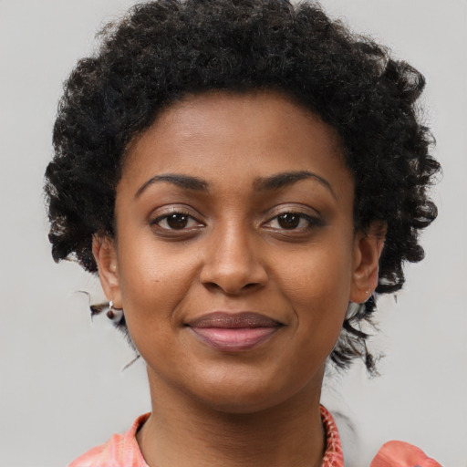 Joyful black young-adult female with short  brown hair and brown eyes