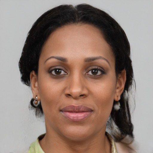 Joyful black adult female with medium  brown hair and brown eyes