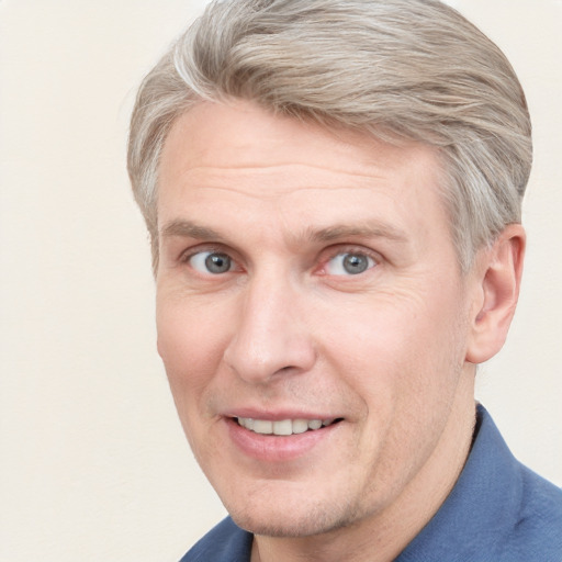 Joyful white adult male with short  brown hair and blue eyes