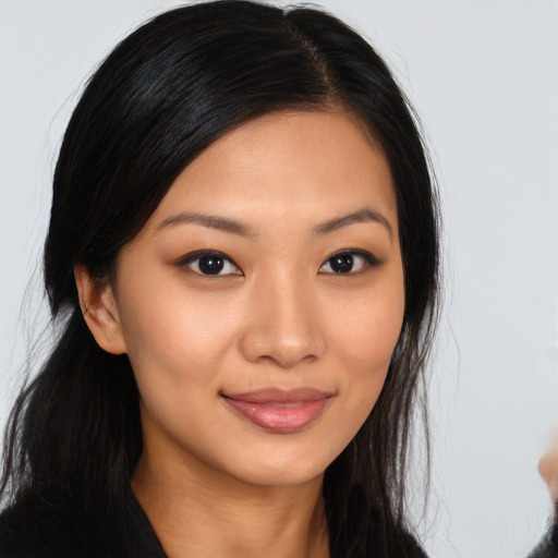 Joyful asian young-adult female with long  brown hair and brown eyes