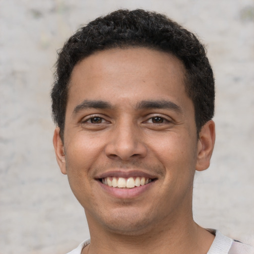 Joyful white young-adult male with short  black hair and brown eyes