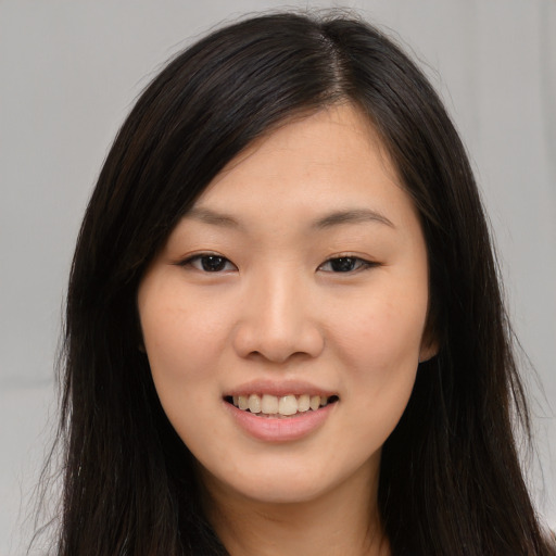 Joyful asian young-adult female with long  brown hair and brown eyes