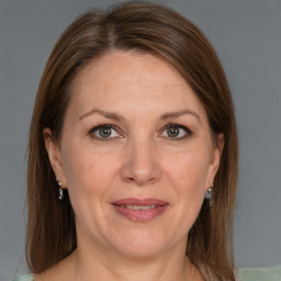 Joyful white adult female with medium  brown hair and grey eyes