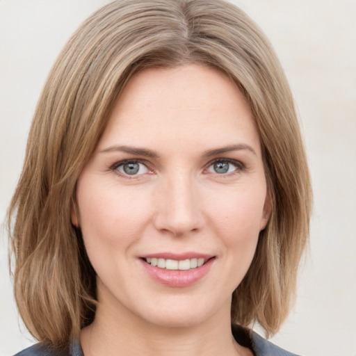 Joyful white young-adult female with medium  brown hair and blue eyes