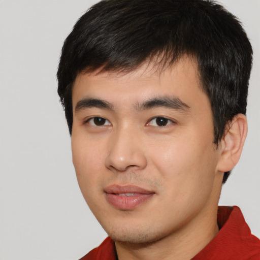 Joyful asian young-adult male with short  black hair and brown eyes