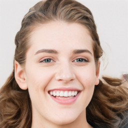 Joyful white young-adult female with long  brown hair and blue eyes