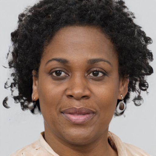 Joyful black adult female with short  brown hair and brown eyes