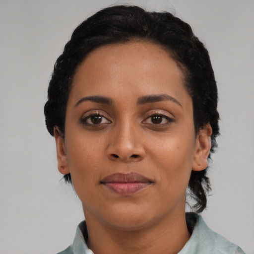 Joyful black young-adult female with short  black hair and brown eyes