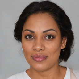 Joyful latino adult female with medium  brown hair and brown eyes