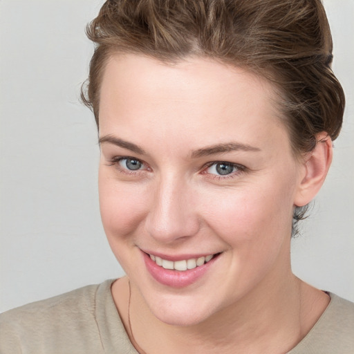 Joyful white young-adult female with short  brown hair and blue eyes