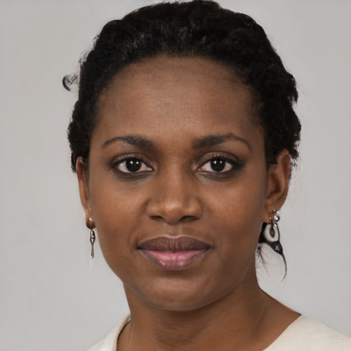 Joyful black young-adult female with short  black hair and brown eyes