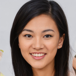 Joyful asian young-adult female with long  brown hair and brown eyes