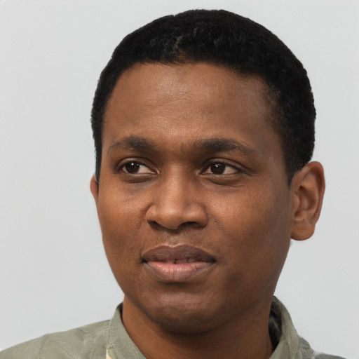 Joyful black young-adult male with short  black hair and brown eyes