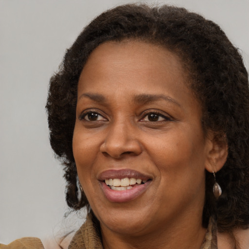 Joyful black adult female with long  brown hair and brown eyes