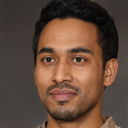 Joyful latino young-adult male with short  black hair and brown eyes