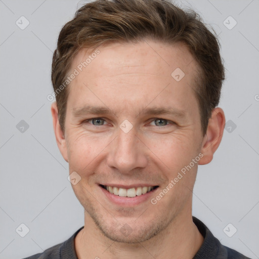 Joyful white adult male with short  brown hair and grey eyes