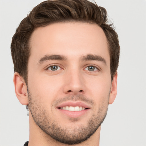 Joyful white young-adult male with short  brown hair and grey eyes