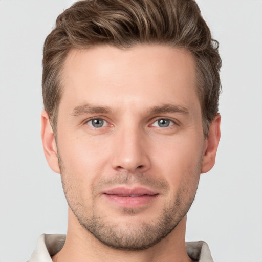 Joyful white young-adult male with short  brown hair and grey eyes