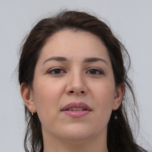 Joyful white young-adult female with long  brown hair and brown eyes