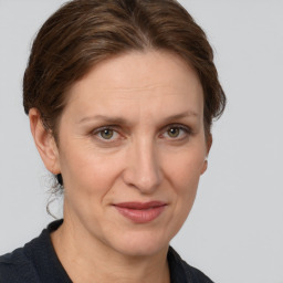 Joyful white adult female with medium  brown hair and grey eyes