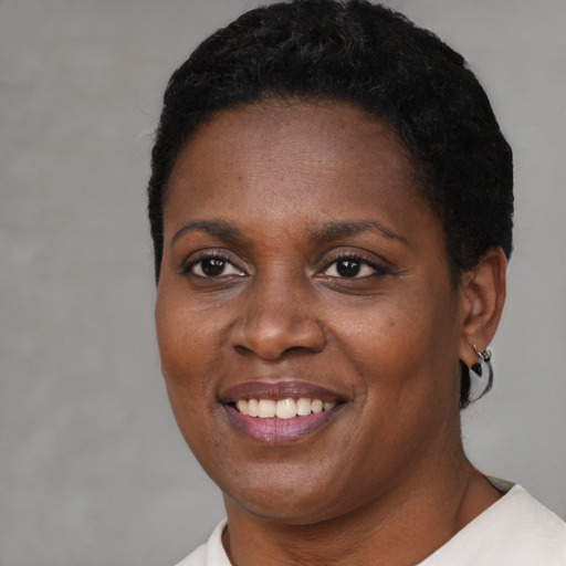 Joyful black young-adult female with short  brown hair and brown eyes