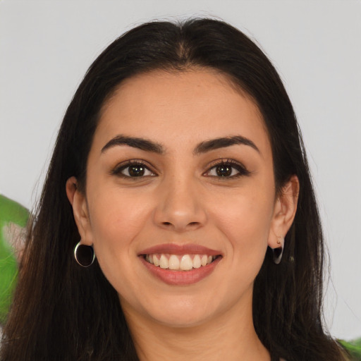 Joyful latino young-adult female with long  brown hair and brown eyes