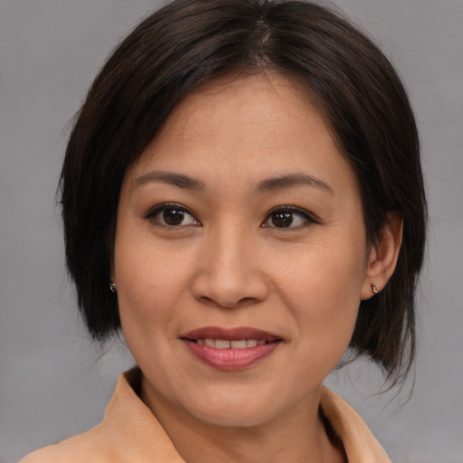 Joyful asian young-adult female with medium  brown hair and brown eyes