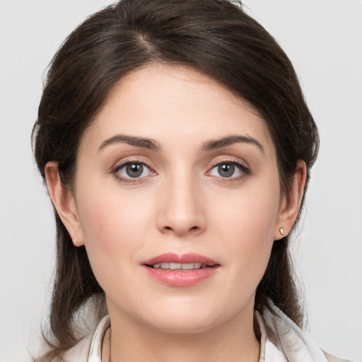 Joyful white young-adult female with medium  brown hair and grey eyes