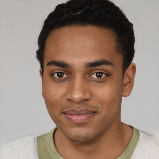 Joyful black young-adult male with short  black hair and brown eyes