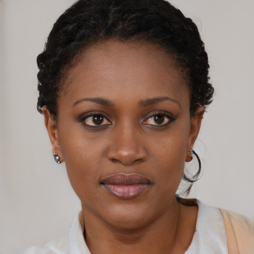 Joyful black young-adult female with short  black hair and brown eyes