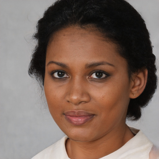 Joyful black young-adult female with short  brown hair and brown eyes