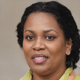 Joyful black adult female with medium  brown hair and brown eyes