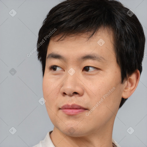 Joyful asian young-adult male with short  black hair and brown eyes