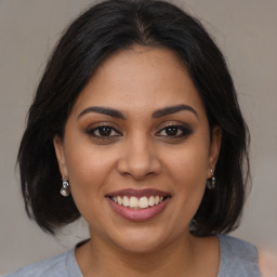 Joyful latino young-adult female with medium  brown hair and brown eyes