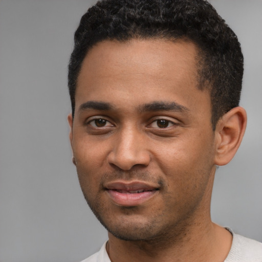 Joyful black young-adult male with short  black hair and brown eyes