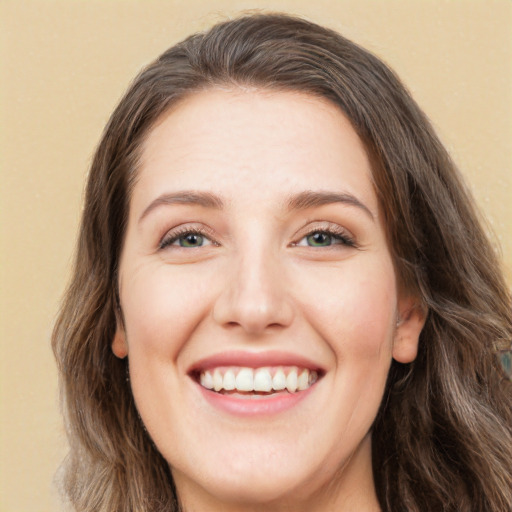 Joyful white young-adult female with long  brown hair and green eyes