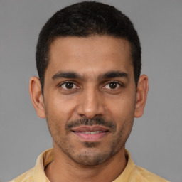 Joyful latino young-adult male with short  brown hair and brown eyes