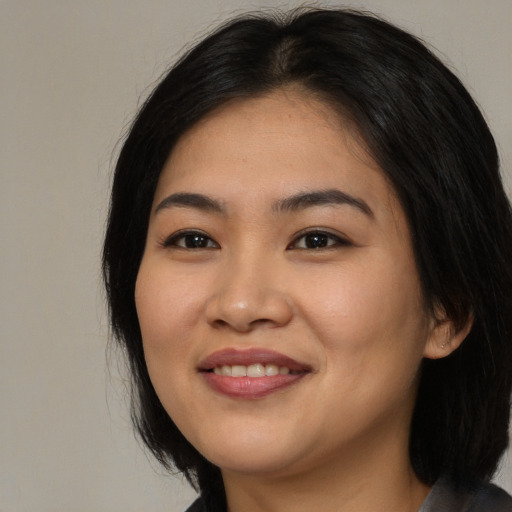 Joyful asian young-adult female with long  black hair and brown eyes