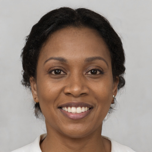 Joyful black adult female with short  brown hair and brown eyes