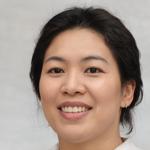 Joyful asian young-adult female with medium  brown hair and brown eyes