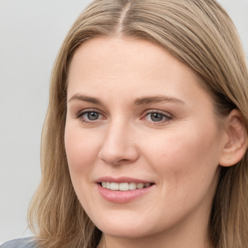 Joyful white young-adult female with long  brown hair and blue eyes