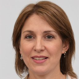 Joyful white adult female with medium  brown hair and grey eyes